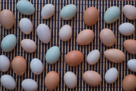 Eggs in various colors on a mat on the kitchen table