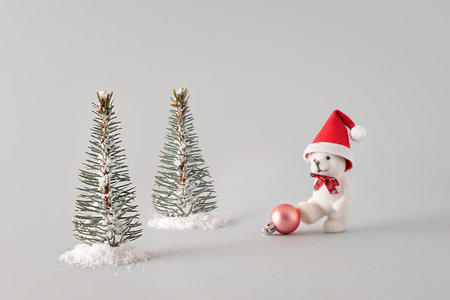 Teddy bear kicking Christmas bubble like a soccer ball towards the goal made of Christmas trees. Minimal game conceptの写真素材