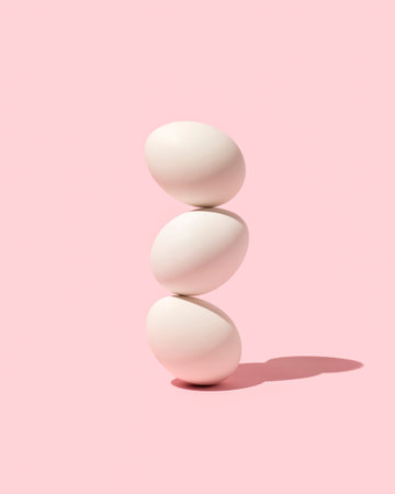 Easter white eggs stacked  on top of each other against pink background. Creative holiday layout. Minimal raw food concept.の写真素材