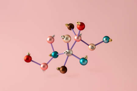 Colorful Christmas balls arranged in a chemical molecular structure. New Year's scientific minimal concept on pink backgroundの写真素材