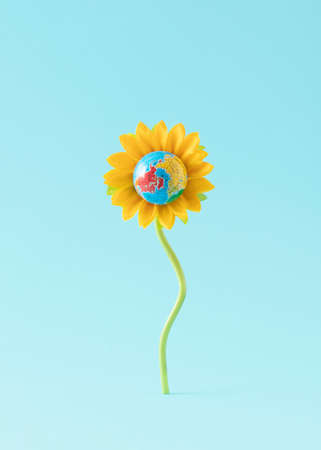 Globe or planet earth in sunflower against blue background. Creative composition of nature blossom....