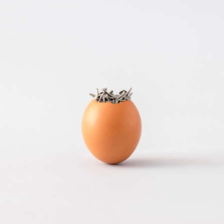 Natural Easter egg with lots of nails against gray background. Creative holiday minimal concept. Art direction composition.の写真素材