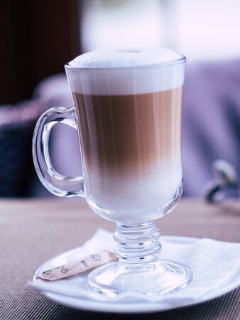 glass with delicious latte in a cozy coffee shopの写真素材