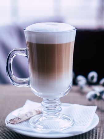 glass with delicious latte in a cozy coffee shopの写真素材