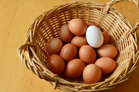Brown and white eggs in a wicker basketの写真素材