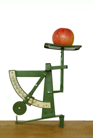 Old fashioned letter scales with apple on white backgroundの写真素材
