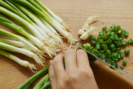 spring onions with wooden cutting boardsの写真素材