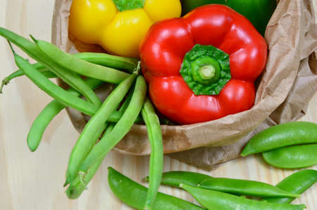 colorful peppers, peas and zucchini on wooden table. Vegetables at a supermarket in any season.の写真素材