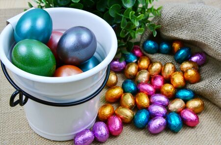 Colorful egg and chocolate for Easter in bucket and bag sackの写真素材