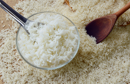 cooked and uncooked rices in glass bowlの写真素材