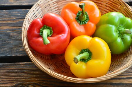 variety of colorful bell pepper or sweet pepper. a lot of Capcicum in basket on wooden background.の写真素材