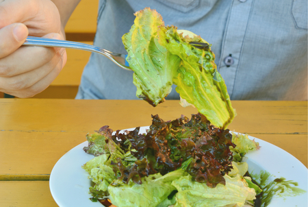 A man eating Green salad with pumpkin oilの写真素材