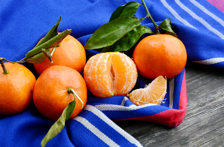 A lot of Clementines, orange or citrus with blue cloth on wooden background.の写真素材