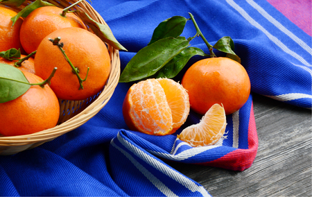 A lot of Clementines, orange or citrus with blue cloth on wooden background.の写真素材