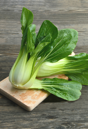 Bok choy or Chinese cabbage on wooden board and wooden floorの写真素材