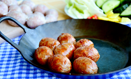 Easten thai sausage (Thai name is sai krok isan) cooked and uncooked with fresh vegetable