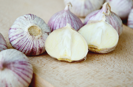 Solo garlic or single clove on wooden broad on sack backgroundの写真素材