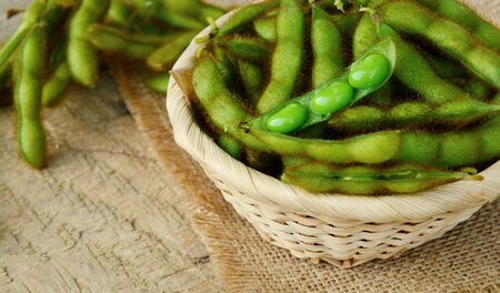 boiled edamame bean or young green soybean on basket on wooden floorの写真素材
