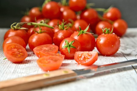 Healthy and benefits of cheery tomatoes.Fresh Cheery tomatoes on white wooden with water drop and knife.の写真素材