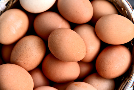Healthy and benefits of chicken egg.Many chicken eggs in basket on wooden background.