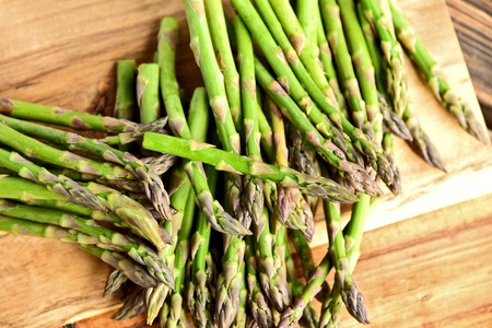 A lot of fresh Green Asparagus (genus) on wooden floorの写真素材