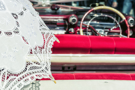 White Lace Umbrella in Vintage Car. Vintage car ready for a drive on a sunny day.の写真素材