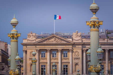 French flag winding and parisian facade architecture in Paris, France