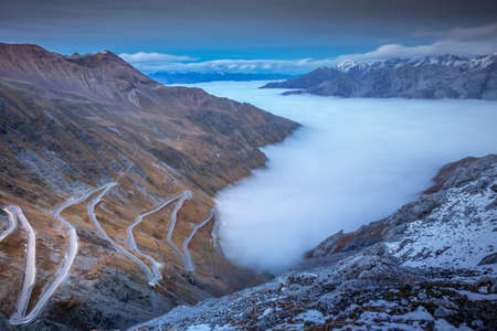 Stelvio pass, mountain road above misty clouds in Italian alps, border with Switzerlandの写真素材