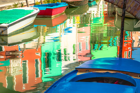 Burano island canal reflection, colorful houses and boats, Venetian lagoonの写真素材