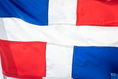 Dominican Republic National Flag Waving against sunny blue sky in Punta Canaの写真素材