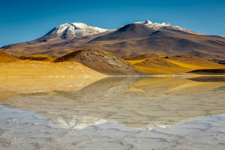Salt lake reflection and idyllic volcanic landscape at sunrise, Atacama desert, Chile border with Boliviaの写真素材
