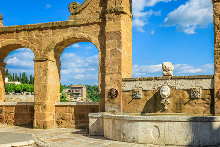 Pitigliano fountain, cityscape square corner and aqueduct, Tuscany, Italyの写真素材