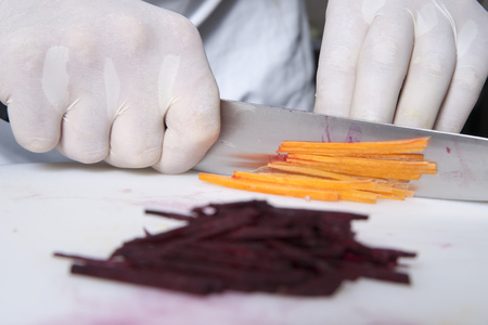 The cook cuts the carrot on the boardの写真素材