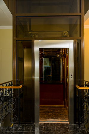 elevator with open metal doors is in the middle of the buildingの写真素材