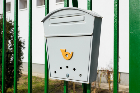 Gray metal mailbox for letters and newspapers on the fenceの写真素材