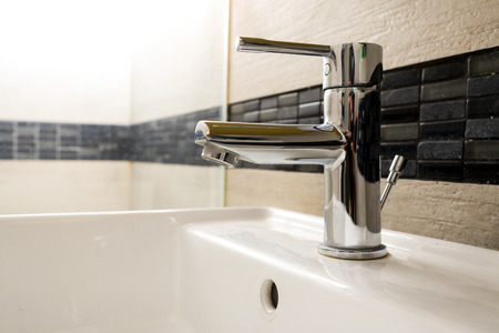 water tap on the washbasin in the bathroomの写真素材