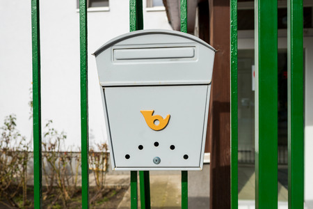 modern gray metal mail boxes on the fence near the buildingの写真素材