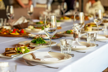 glasses for wine and a beautifully decorated table with snacks in the restaurantの写真素材