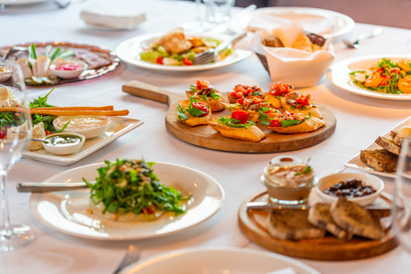 croutons with bacon and vegetables on a wooden tray on a banquet tableの写真素材