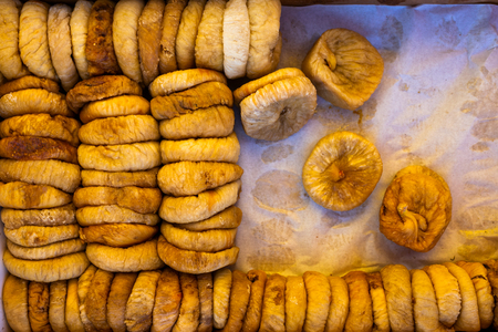 Dried figs in a box on parchment paper for transportation and sale, floral backgroundの写真素材