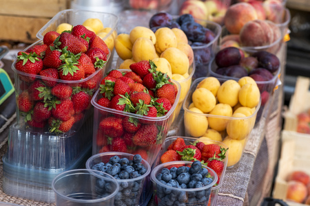fresh strawberries in plastic in the store and other fruits and berriesの写真素材