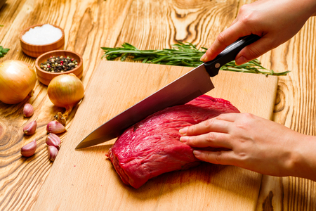 woman preparing fresh meat in the kitchenの写真素材