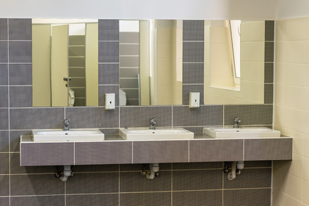 washbasins with mirrors on the wall in the toilet