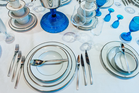 Dishes with glasses and cutlery on the decorated table in the store