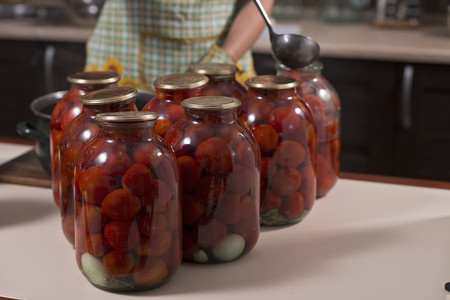 homemade tomatoes prepared for canning houses in glass jarsの写真素材