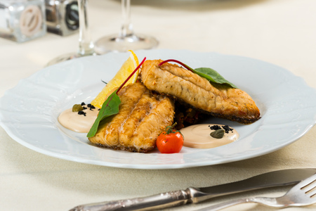 fried fish fillet with vegetables with parmesan sauceの写真素材