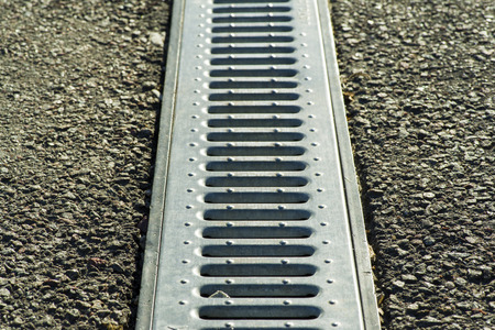 Gutter cover or sewer drain on roadside. street rain gutter