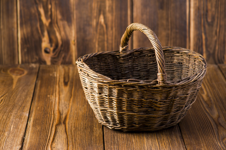 wicker basket of wicker on a dark wooden tableの写真素材