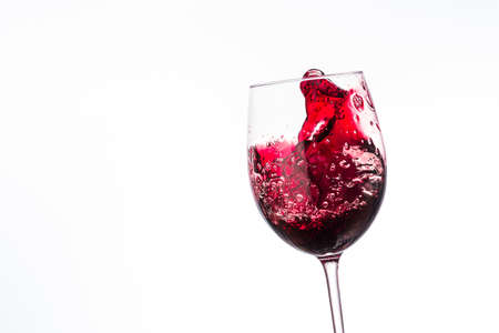wine splashes in glasses isolated on white background, splash of wine in a glass close upの写真素材