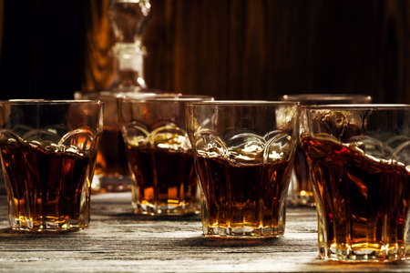 Elite alcoholic drink for men, full glasses on the table in the bar, brandy in glassesの写真素材